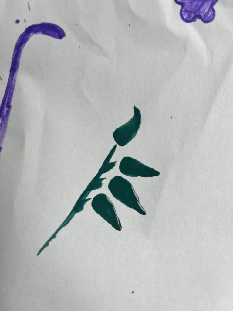a branch painted with green paint using a simple brush mark to represent leaves